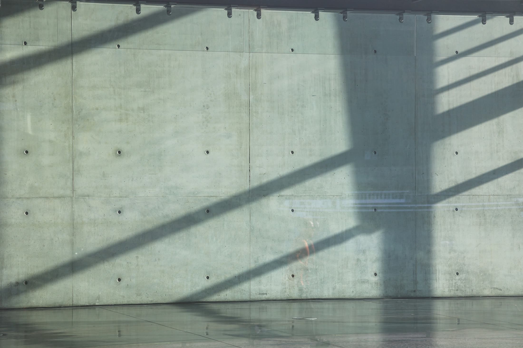 Light and shadow across a board-formed concrete wall